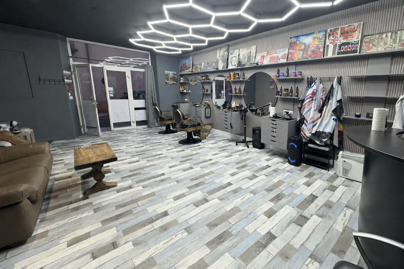 Vue d'ensemble du salon Coiffeur City, plafond hexagonal LED et fauteuils de barbier